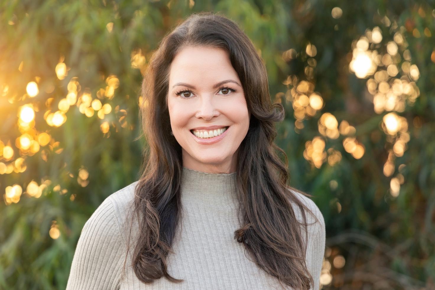 Woman with dark brown hair standing